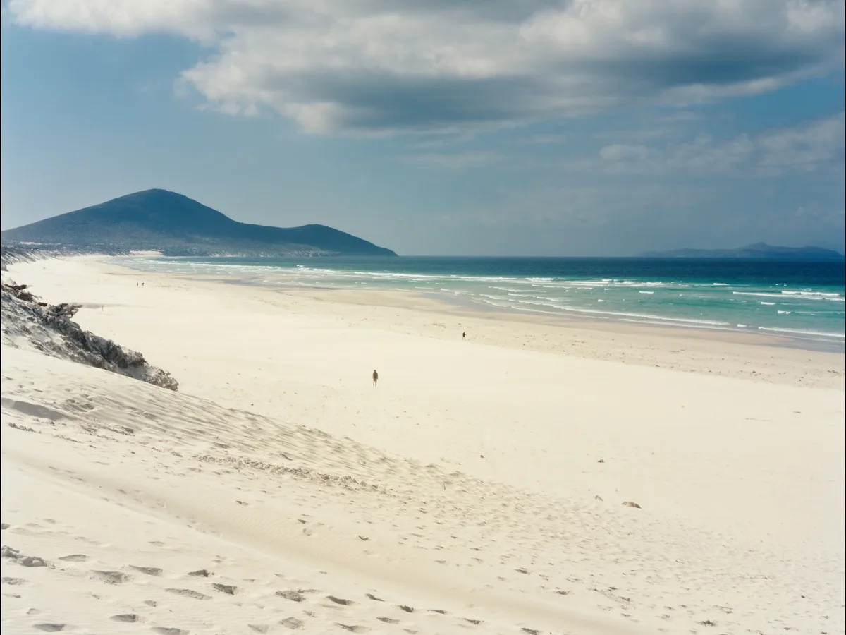 AI-generated image: a vast empty white-sand beach and turquoise shallows, typical of the Fuerteventura coast