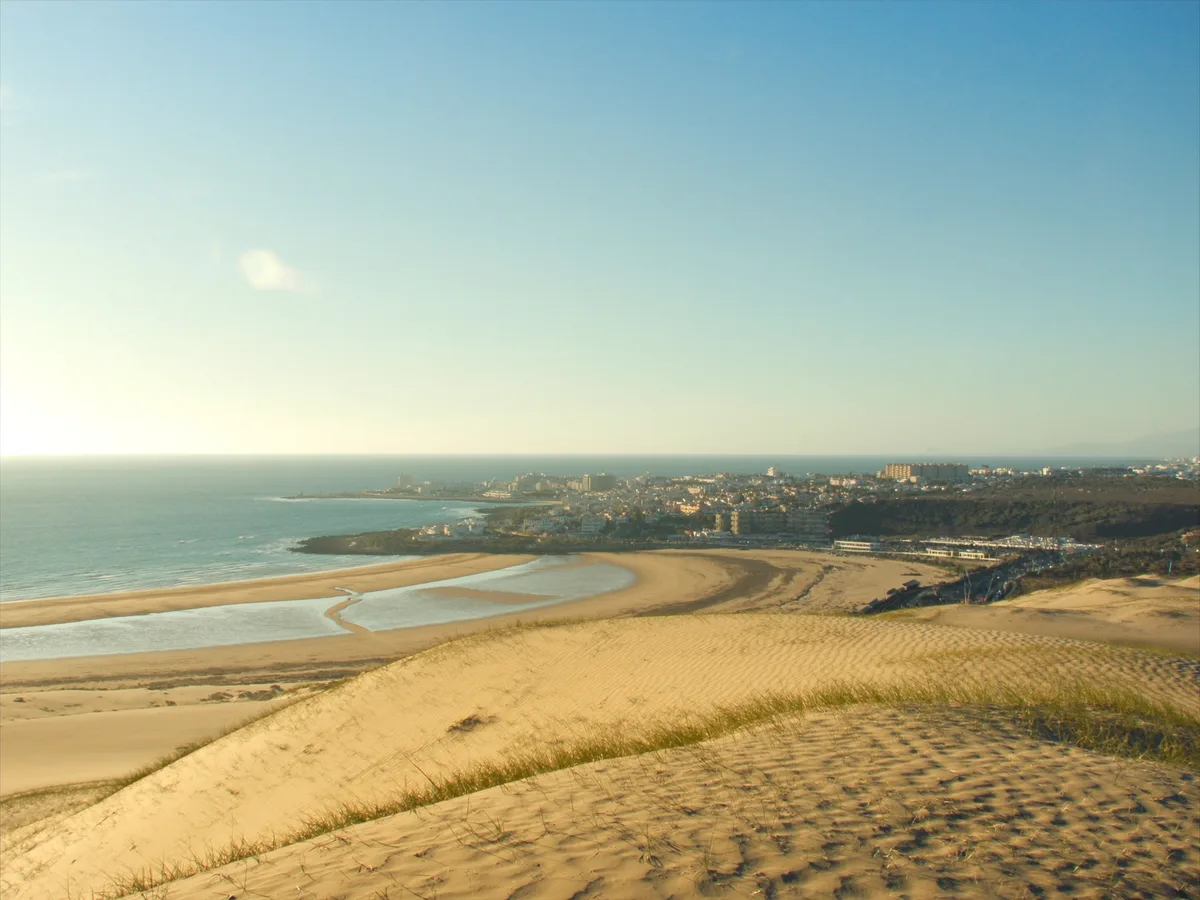 AI-gegenereerde afbeelding: door de wind geribbelde gouden duinen aan de Atlantische Oceaan, typisch voor de kust van Maspalomas op Gran Canaria