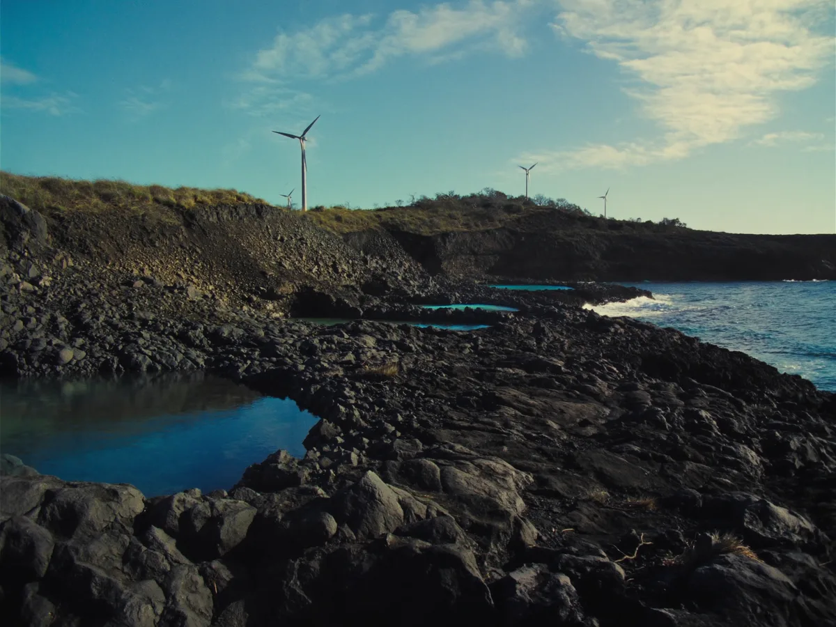 KI-generiertes Bild: raue schwarze Vulkanküste mit natürlichen Gezeitenbecken im Fels, typisch für El Hierro